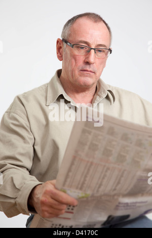 Reifer Mann der 50er Jahre eine Broadsheet-Zeitung lesen. Stockfoto