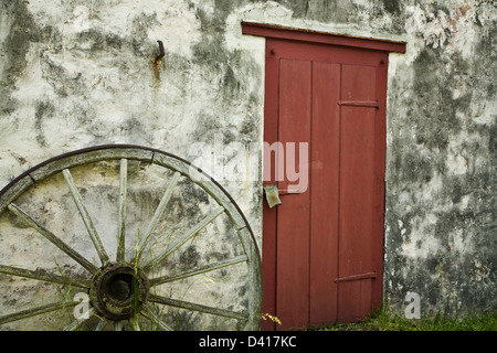Vintage wagon wheel & eine Nahaufnahme der roten Tür Abstract Am historischen Hopewell Furnace in Berks County, Pennsylvania, USA Stockfoto