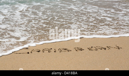 Karibische Worte geschrieben in Sand am Strand vom Meer in St. Thomas Stockfoto