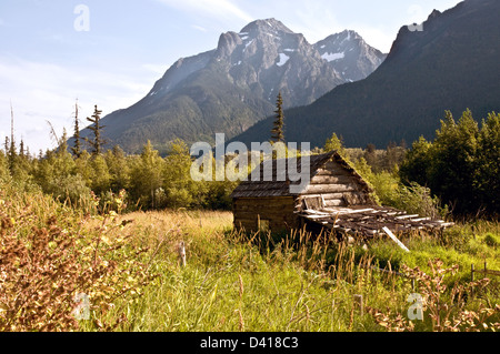 Einer kleinen Blockhütte unter Missachtung Berg in der abgelegenen Bella Coola Valley, British Columbia, Pacific Coast Ranges, Kanada. Stockfoto