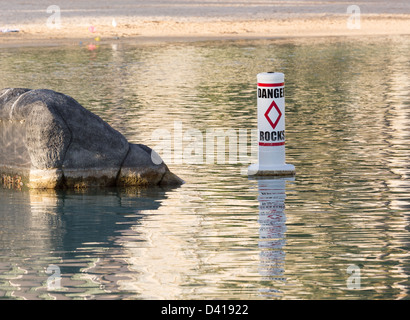 Humorvolle Zeichen für Gefahr Felsen im kleinen Pool mit einzelnen Felsen Stockfoto