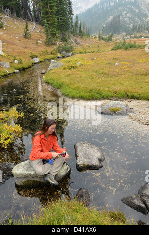 Wanderer, die Filterung von Wasser auf eine Rucksack-Reise in Oregon Wallowa Mountains. Stockfoto
