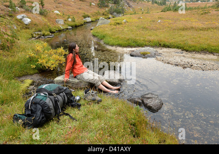 Wanderer durchnässten Füße in einem Bach hoch oben auf einem Rucksack Reise in Oregon Wallowa Mountains. Stockfoto