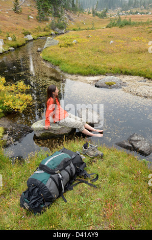 Wanderer durchnässten Füße in einem Bach hoch oben auf einem Rucksack Reise in Oregon Wallowa Mountains. Stockfoto