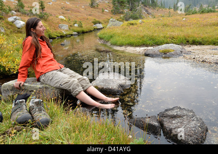 Wanderer durchnässten Füße in einem Bach hoch oben auf einem Rucksack Reise in Oregon Wallowa Mountains. Stockfoto
