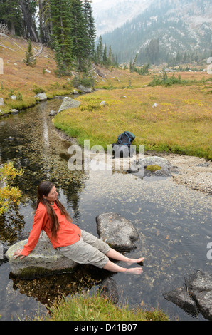 Wanderer durchnässten Füße in einem Bach hoch oben auf einem Rucksack Reise in Oregon Wallowa Mountains. Stockfoto