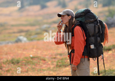 Frau trinkt aus einem Rohr Hydration Rucksack unterwegs in Oregon Wallowa Mountains. Stockfoto