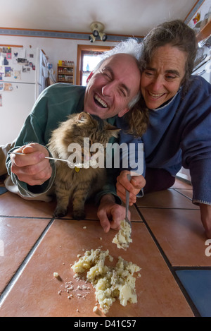 Paar und Katze essen Kartoffeln einen sauberen Boden. Stockfoto