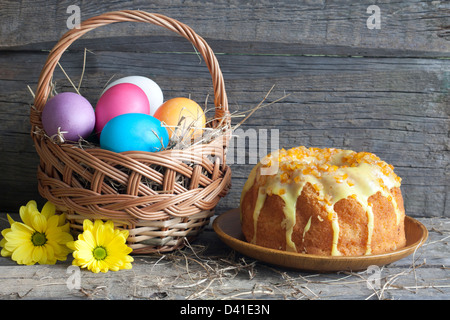 Ostereier im Korb und Kuchen auf Vintage Holztisch Stockfoto