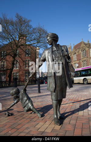 Mutter und Kind greifen nach einer Teddybären-Skulptur eine Wahrzeichen-Statue aus dem 21.. Jahrhundert am Blackburn Boulevard, Pennine Lancashire, Großbritannien Stockfoto