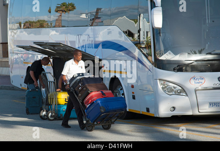 Porter mit Gastes Koffer auf einem Wagen. Entladung von einem Tour-Bus in Südafrika Stockfoto