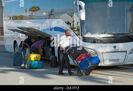 Porter mit Gastes Koffer auf einem Wagen. Entladung von einem Tour-Bus in Südafrika Stockfoto