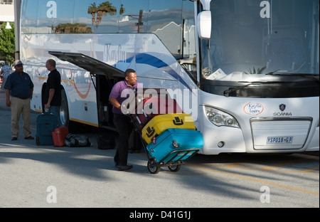 Porter mit Gastes Koffer auf einem Wagen. Entladung von einem Tour-Bus in Südafrika Stockfoto