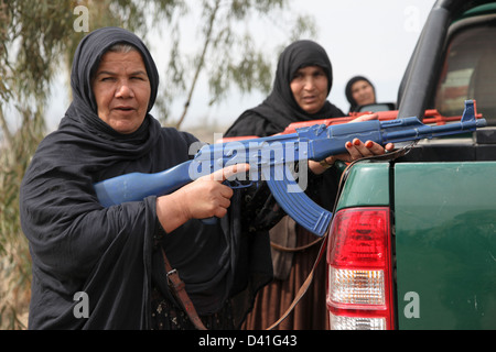 Afghanische Uniform Polizei Frauen schwingen Trainingswaffen und in Deckung hinter einem Polizeifahrzeug hatten während der Durchführung einer risikoreiche Verkehr Stop Übung 25. Februar 2013 in Khost Provinz, Afghanistan. Stockfoto