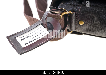 Gepäck-Label mit gedruckten Namen, Adresse und Telefon Nummer. Eine Umhängetasche gesichert. Stockfoto