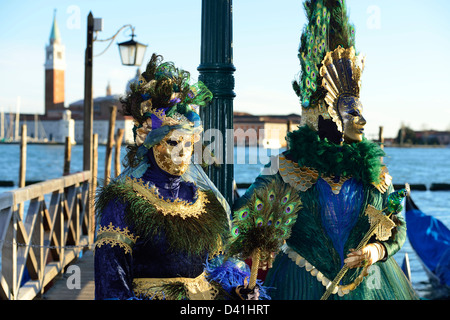 Zwei Masken stehen vor der Insel San Giorgio Maggiore in Venedig Karneval 2013; Veneto, Italien. Stockfoto