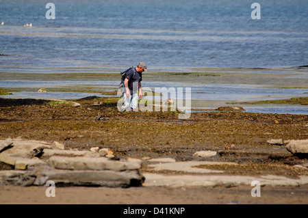 Ein Mann Rock Bündelung im breiten Sims Lyme Regis Stockfoto