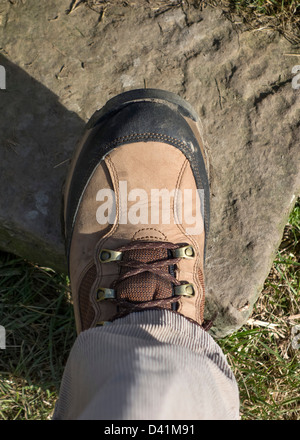 Nahaufnahme des Gehens Boot auf der Stufe des einen Stein Stil auf einem öffentlichen Wanderweg, UK Stockfoto