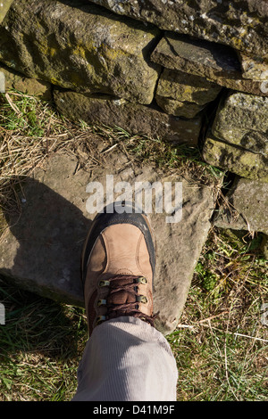 Nahaufnahme des Gehens Boot auf der Stufe des einen Stein Stil auf einem öffentlichen Wanderweg, UK Stockfoto