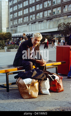 Berlin, DDR, Senior sitzt nachdenklich auf einer Straße Bank Stockfoto