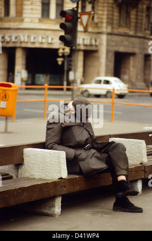 Berlin, DDR, Alter Mann schläft auf einer Straße Bank Stockfoto