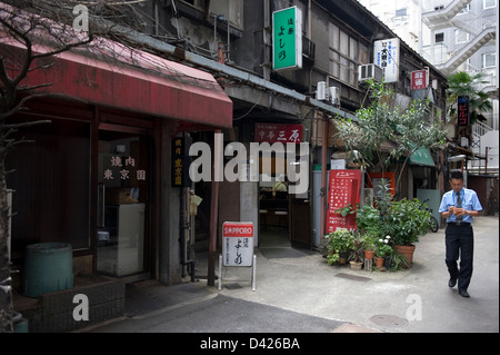 Patron verlassen einer Gaststätte auf der Rückseite Gasse in gehobenen Ginza Bezirk in Tokio. Solche Betriebe aus den 1950er Jahren verschwinden Stockfoto