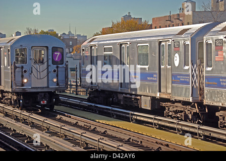 Zwei erhöhte #7 u-Bahn-Züge gehen in entgegengesetzte Richtungen in Queens, New York Stockfoto