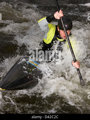 Wildwasser-Kanuten drehen Kanu mit Paddel Stockfoto