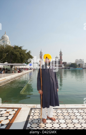 Ein uniformierter Tempelwächter mit Speer auf den goldenen Tempel in Amritsar Punjab Indien Komplex Stockfoto