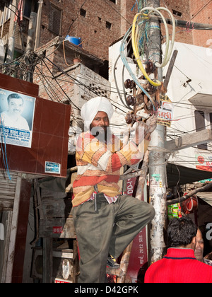 Ein Sikh Elektriker Befestigung von Leitungen in der Heiligen Stadt Amritsar im Punjab, Indien Stockfoto