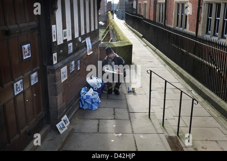 Männliche Künstler sitzt auf Chester City Wände malen im Freien Stockfoto