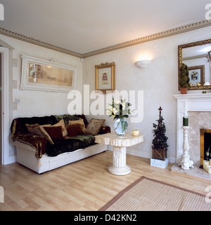 Kunstpelz Wurf auf weißen Sofa in weiß Wohnzimmer mit kleinen steinernen Sockel Tisch und Holz Laminatfußböden Stockfoto