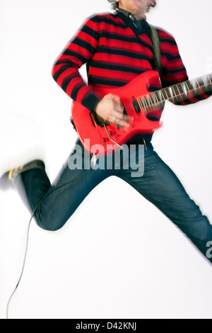 Freiburg, Deutschland, ein junger Mann mit e-Gitarre in die Luft springen Stockfoto