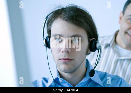 Freiburg im Breisgau, Mann mit Kopfhörer auf einem Computermonitor Stockfoto