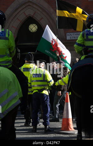 EDL-Anhänger kommen am Albert Square eine walisische Flagge. Demo geht aus relativ friedlich - mit einem massiven Polizeieinsatz halten ganz rechts English Defence League (EDL)-Befürwortern und Gegnern, unter der Leitung von Vereinen gegen Faschismus (UAF), auseinander, wie sie am Albert Square konvergiert. Manchester, England, Vereinigtes Königreich. Samstag, 2. März 2013 Stockfoto