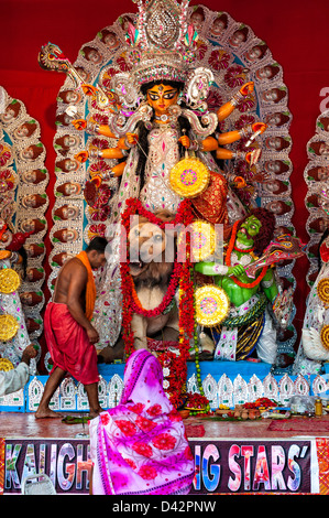 Eine Frau im Sari rundet ihre Puja an die Göttin Durga im, display, in der Nähe von Chowringhee, Kolkata, Indien während Durga Puja. Stockfoto