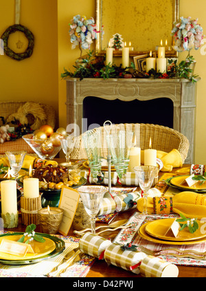 Gelbe Platten und Servietten und hausgemachte Kekse am Tisch für Weihnachtsessen im gelben Speisesaal Stockfoto