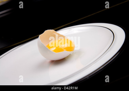 Berlin, Deutschland, eröffnet ein rohes Ei auf einem Teller Stockfoto