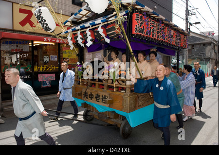 Wagen mit MusikerInnen, die traditionellen Kimono tragen wird durch eine Nachbarschaft während Sanja Matsuri Festival, Tokyo gezogen. Stockfoto