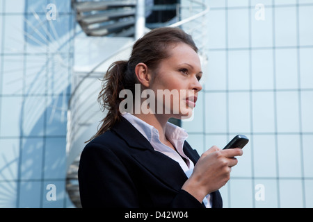 Freiburg, Deutschland, eine junge Geschäftsfrau mit Handy Stockfoto