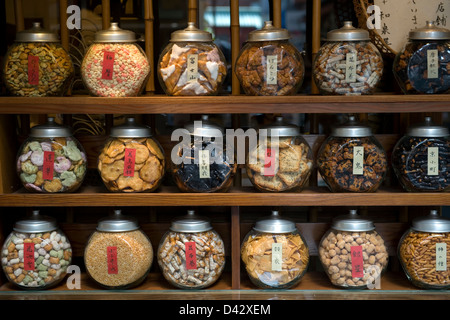 Senbei (großen Reis-Cracker), Arare (mundgerechte Kekse) und andere Snacks auf dem Display in separaten Gläsern in einem Shop in Tokyo Stockfoto