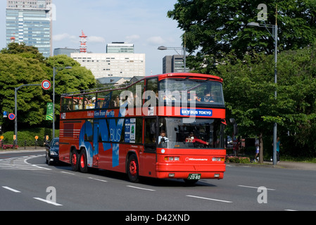 Einem offenen Doppeldeckerbus Tour voller Touristen macht es Runde zu berühmten Sehenswürdigkeiten Tokios. Stockfoto