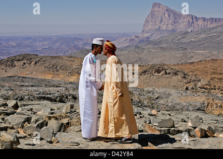 Omanische Männer berühren Nasen in Gruß, Jebel Misht im Hintergrund, Oman Stockfoto