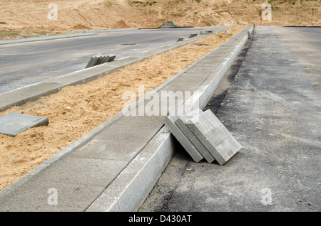 Pflaster-Fliesen auf neue Bürgersteig. neue Autobahn Asphaltstraßenbau funktioniert. Stockfoto