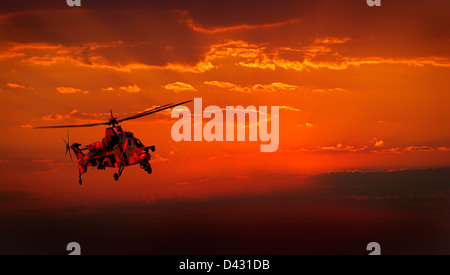 Eine getarnte Militärhubschrauber auf der Flucht vor einem dramatischen roten Himmel Stockfoto