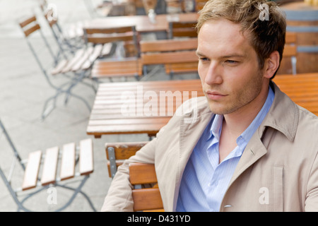 Gut aussehender Mann in smart casual Kleidung in einem Straßencafé sitzen Stockfoto