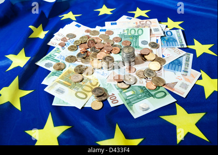 Hamburg, Deutschland, Euro-Banknoten und Euromuenzen auf eine europäische Flagge Stockfoto
