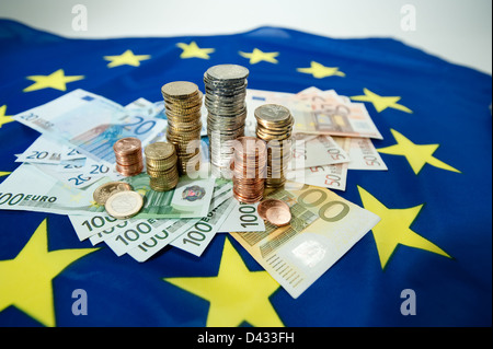 Hamburg, Deutschland, Euro-Banknoten und Euromuenzen auf eine europäische Flagge Stockfoto