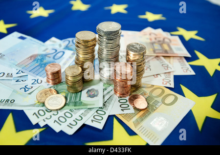 Hamburg, Deutschland, Euro-Banknoten und Euromuenzen auf eine europäische Flagge Stockfoto