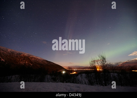 schwache weiße und grüne Streifen von Nordlicht Aurora Borealis über Fjord in der Nähe von Tromsø in Norwegen Nordeuropa Stockfoto